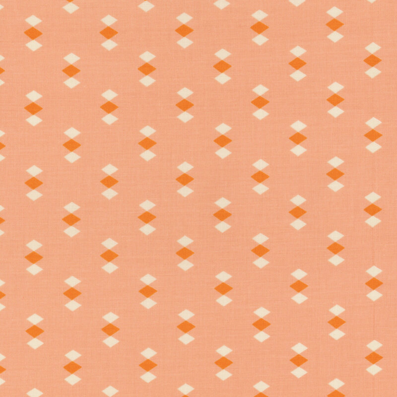 Light peach fabric featuring evenly spaced clusters of orange and white diamonds throughout