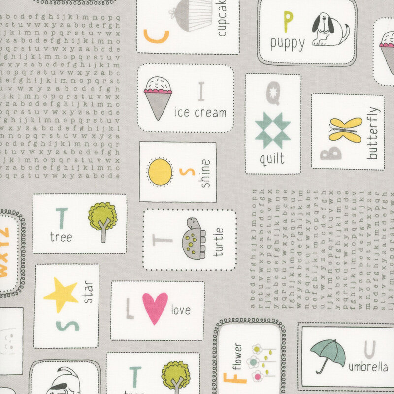 Gray fabric with a pattern of illustrated flash cards for kids featuring the alphabet and various drawings