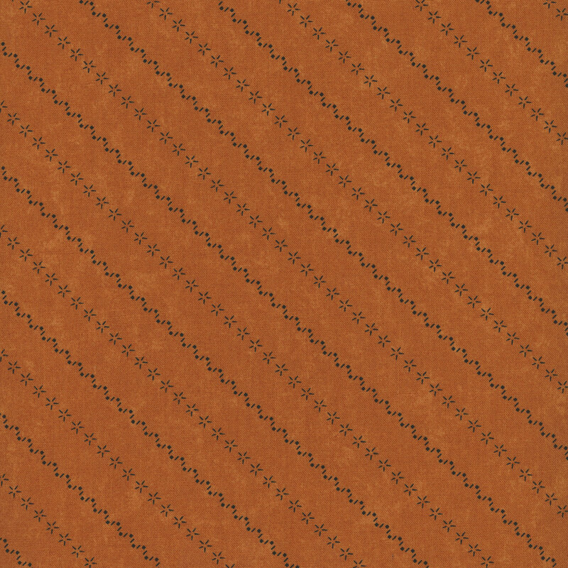 Rusty orange mottled fabric with alternating diagonal stripes made of stars and zig-zag patterns.