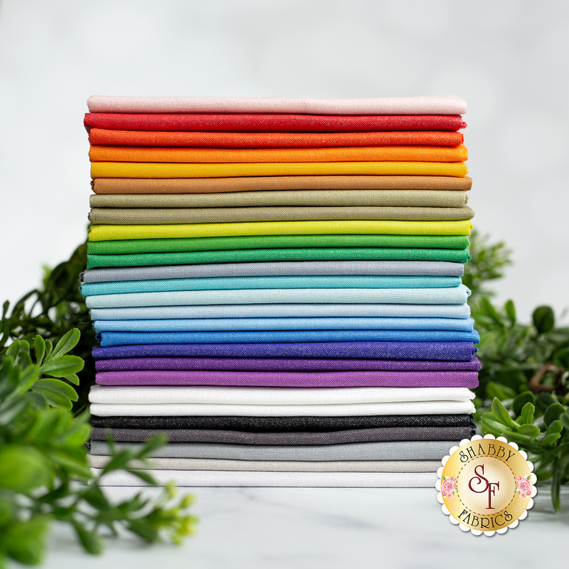 A photo of fabrics included in the Kona Sheen FQ Set stacked in rainbow order