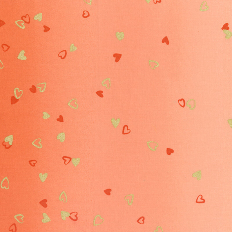 peach fabric featuring an ombre design with small metallic and orange hearts