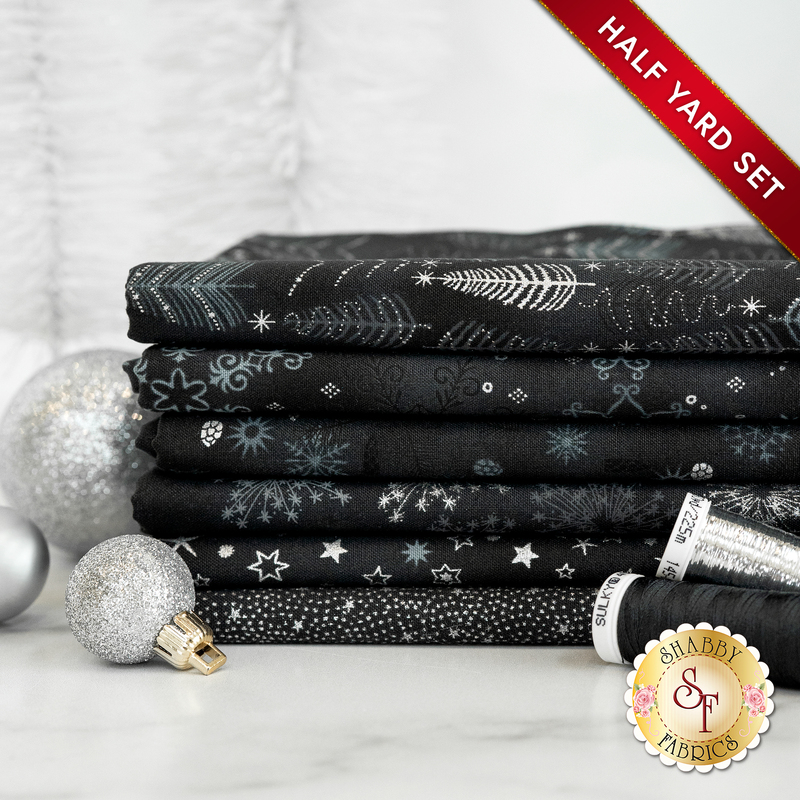 A photograph of the stacked half yards included in the Black/Silver set, staged with black thread and sparkling silver ornaments.