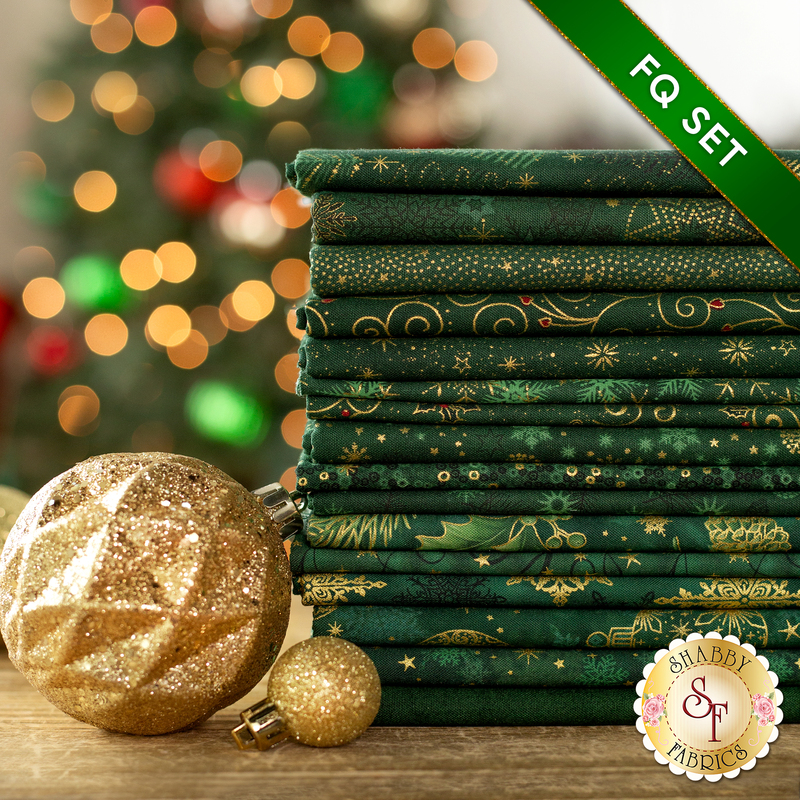 A photograph of the stacked fat quarters included in the Green/Gold set, staged with gold decor and ornaments.