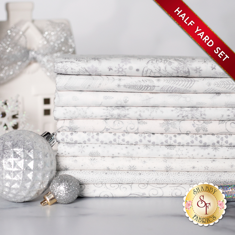 A photograph of the stacked half yards included in the White/Silver set, staged with silver holoshimmer thread and sparkling silver decor and ornaments.