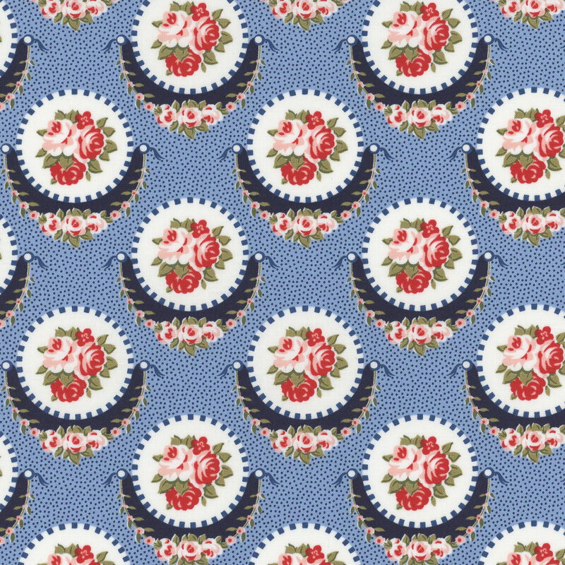 Section of a light blue fabric with large navy and white medallions with clustered pink flowers inside.