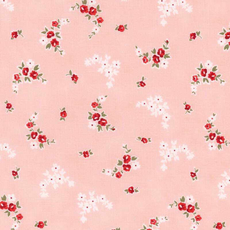 Section of a pink fabric with scattered small red and white flowers.