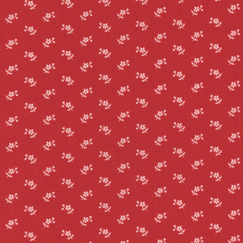 Section of a red fabric with small pink flowers and berries.
