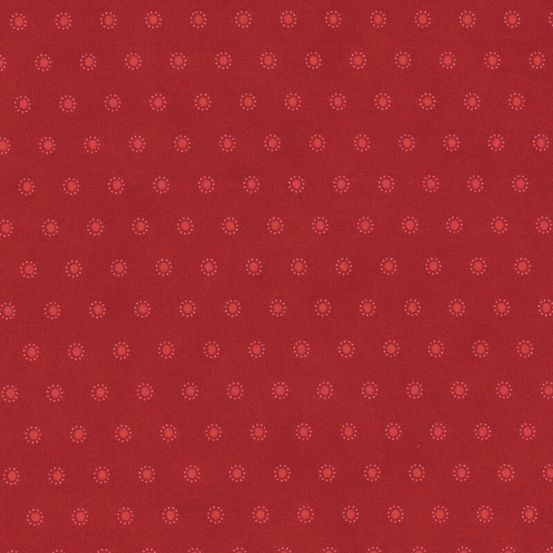Section of a red fabric with small rows of red circles surrounded by smaller dots.