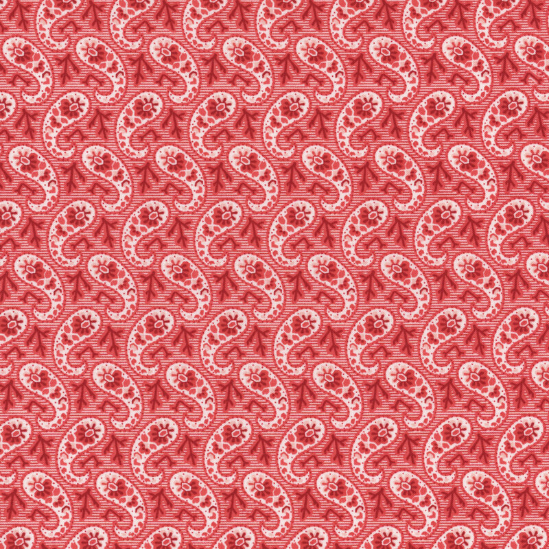 Section of a red fabric with a paisley pattern made up of red branches and flowers.