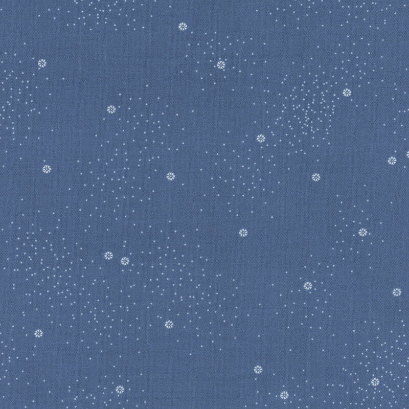A denim-blue fabric with small white daisies and little white speckles throughout