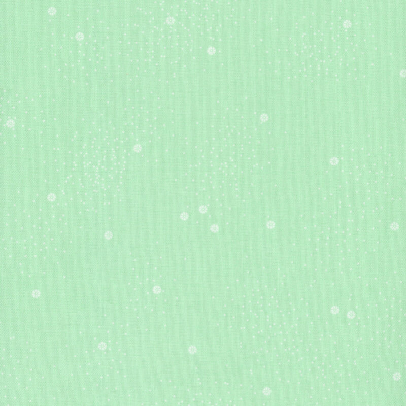 A mint green fabric with small white daisies and little white speckles throughout