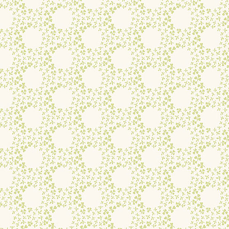 A white fabric with small green clovers forming rings