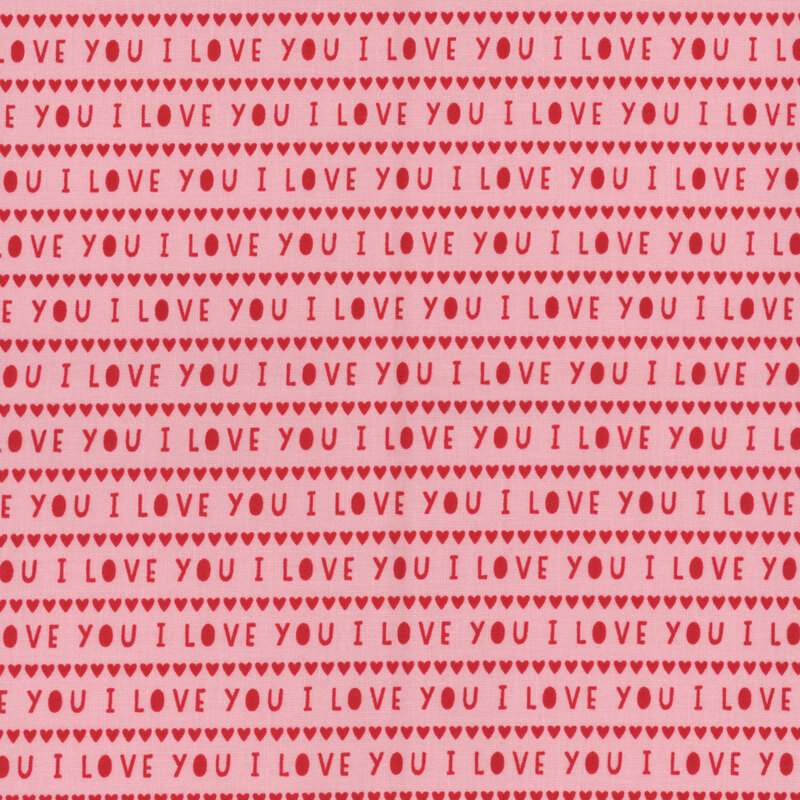 Light pink fabric with rows of small red hearts and the words 