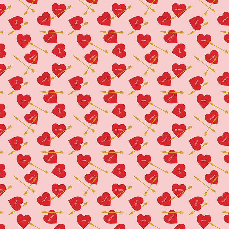 Light pink fabric with small, red ditsy hearts and gold arrows throughout