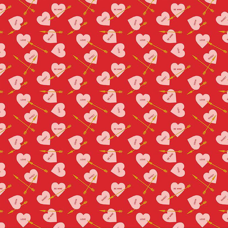 Bright red fabric with small pink ditsy hearts and golden arrows throughout