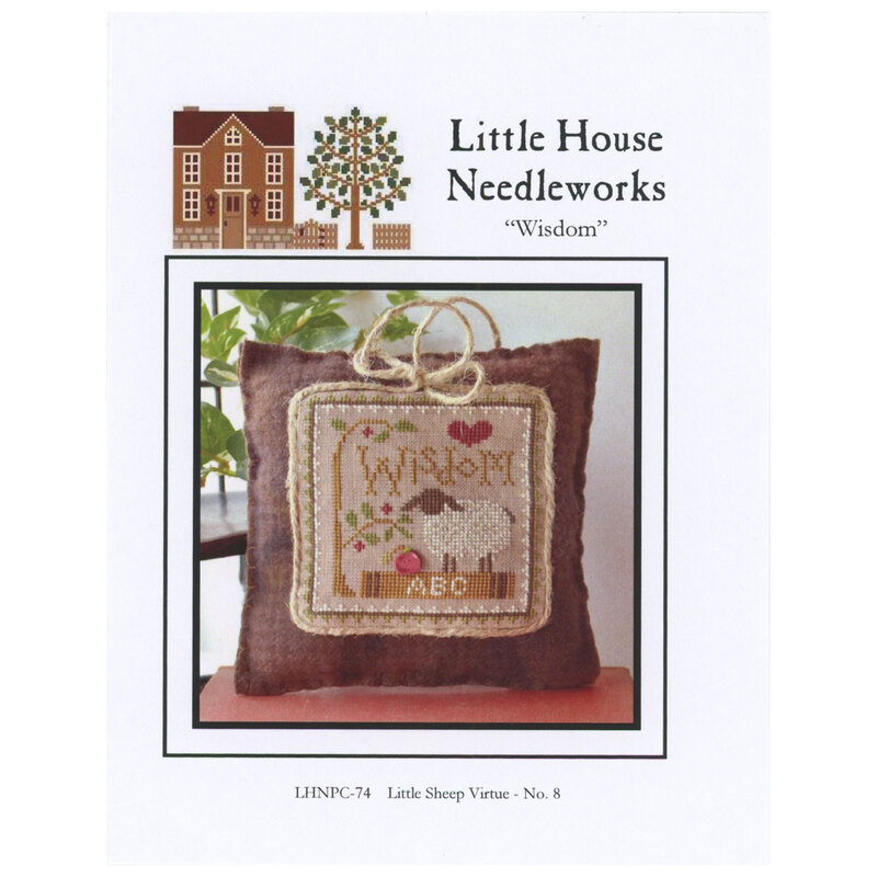 Front of pattern showing the completed cross stitch on a small ornament pillow staged on a table in front of leaves