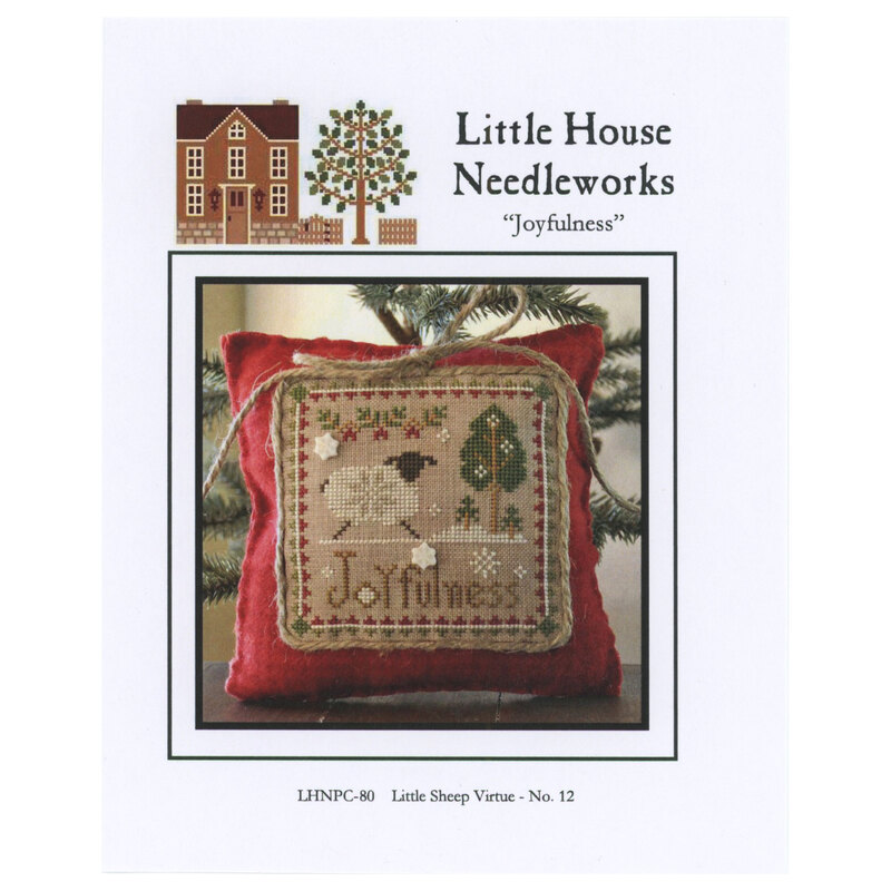 Front of pattern showing the completed cross stitch on a small ornament pillow staged on a table in front of a small christmas tree