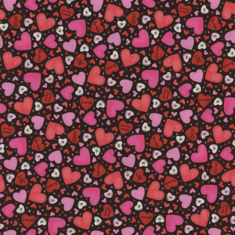 Black fabric covered in pink, red, and white hearts of varying sizes