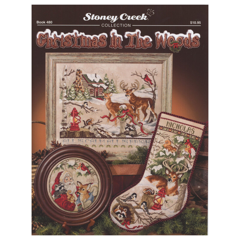 Front of cross stitch pattern showing the finished designs displayed on a table with pinecones and christmas garland greenery