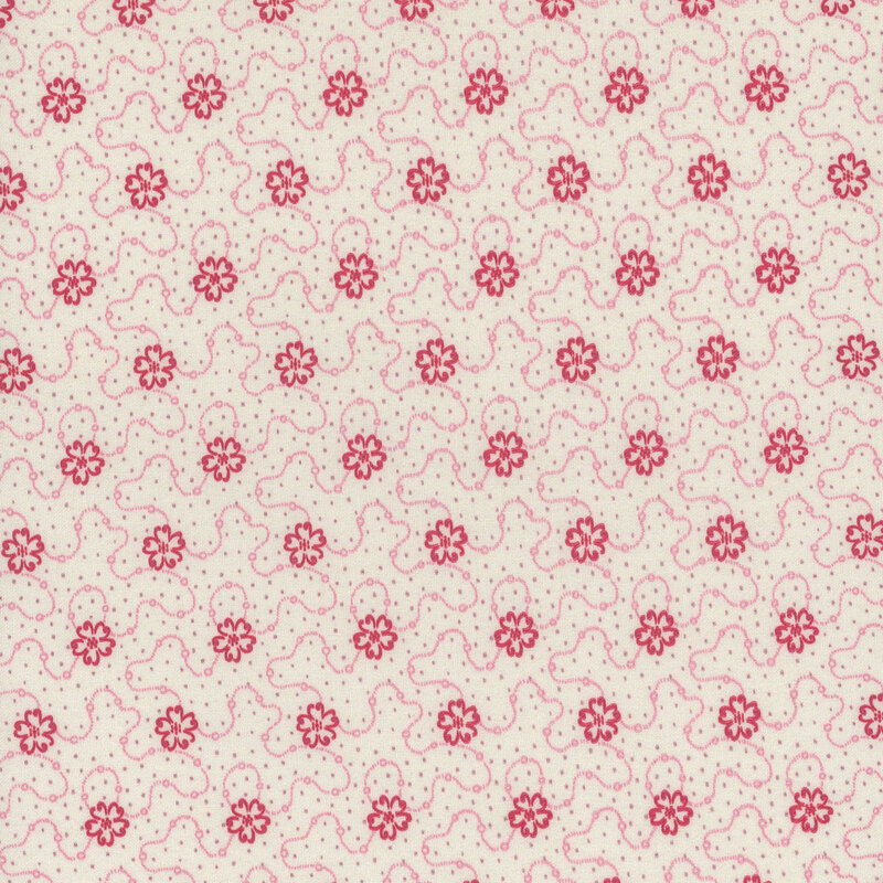 Cream fabric featuring a swirly dotted design with red flowers and scattered gray dots