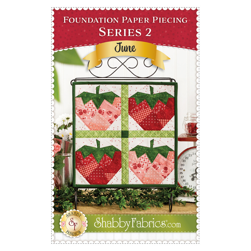 Front cover of the Foundation Paper Piecing Series 2 June pattern, featuring a photo of the finished project, a wall hanging with four quilt blocks of foundation paper pieced strawberries