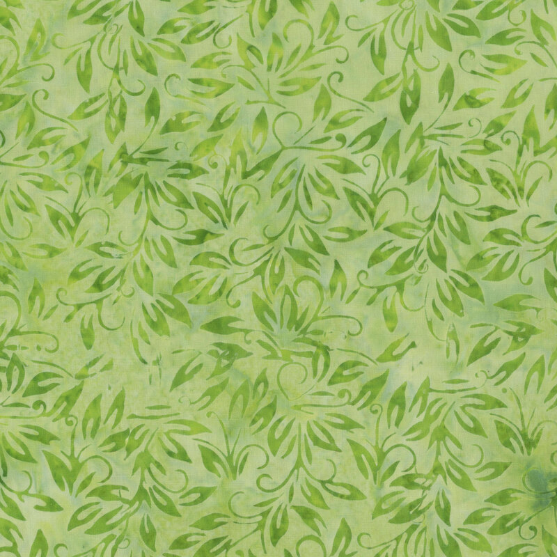 Mottled tonal green batik fabric with dark green leaves throughout