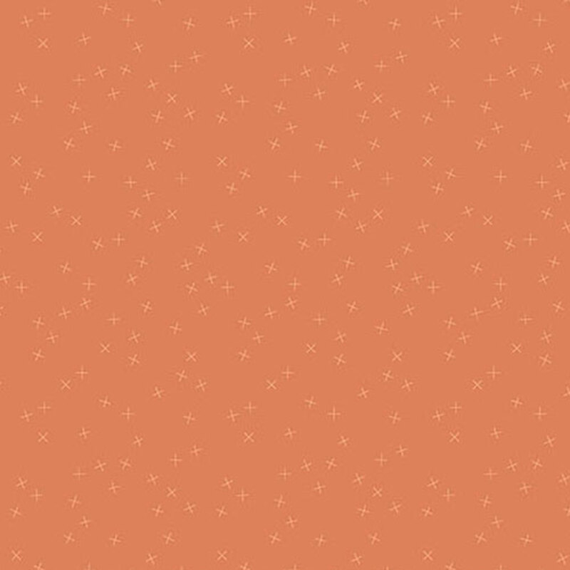 Medium orange fabric with small tonal light orange X's scattered throughout