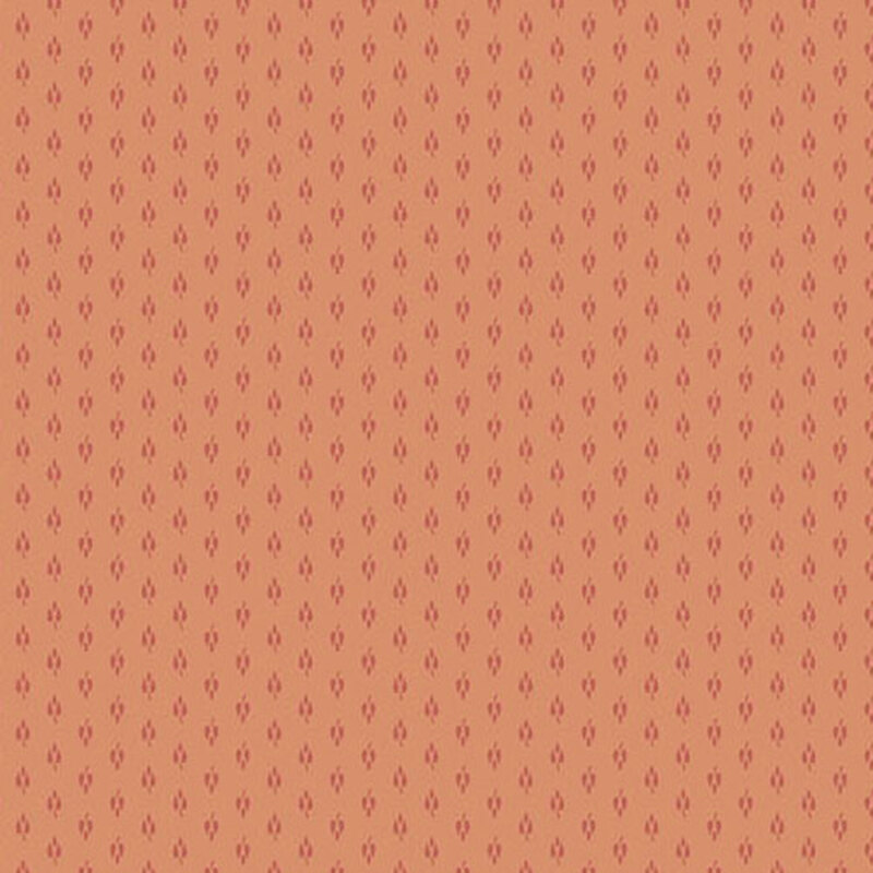 Light peach fabric with small red repeating shapes all over
