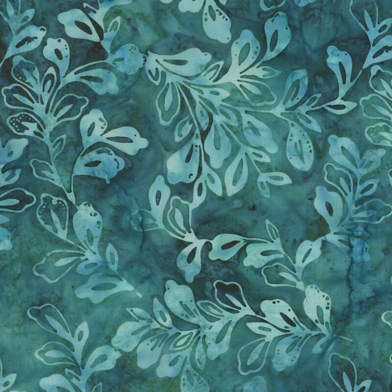 Mottled batik fabric with pale green and aqua leaves and sprigs tossed on a teal background