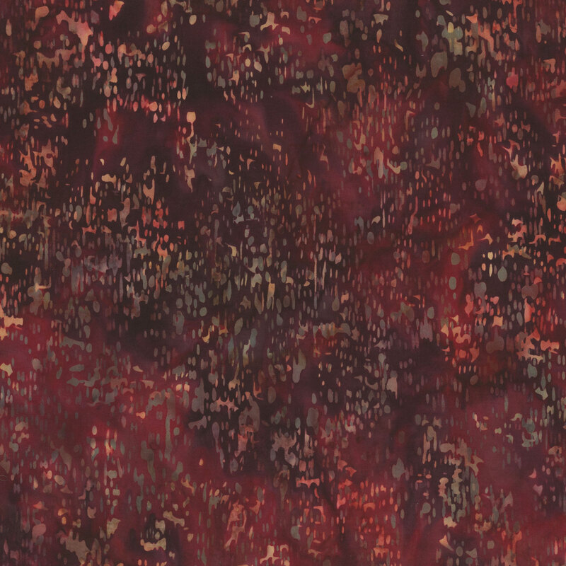Red batik fabric with a speckled pattern.
