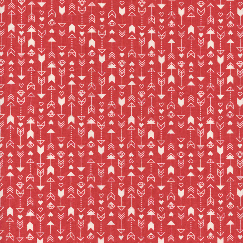 red fabric featuring a pattern of arrows, hearts and diamonds