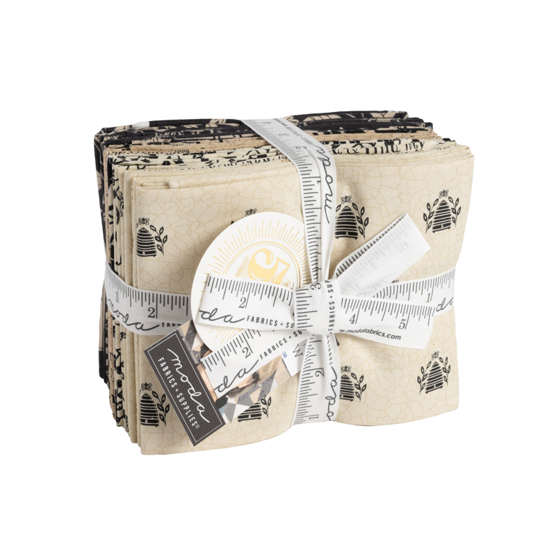 A bundle of cream, tan, and black fat quarters wrapped in a white ruler ribbon