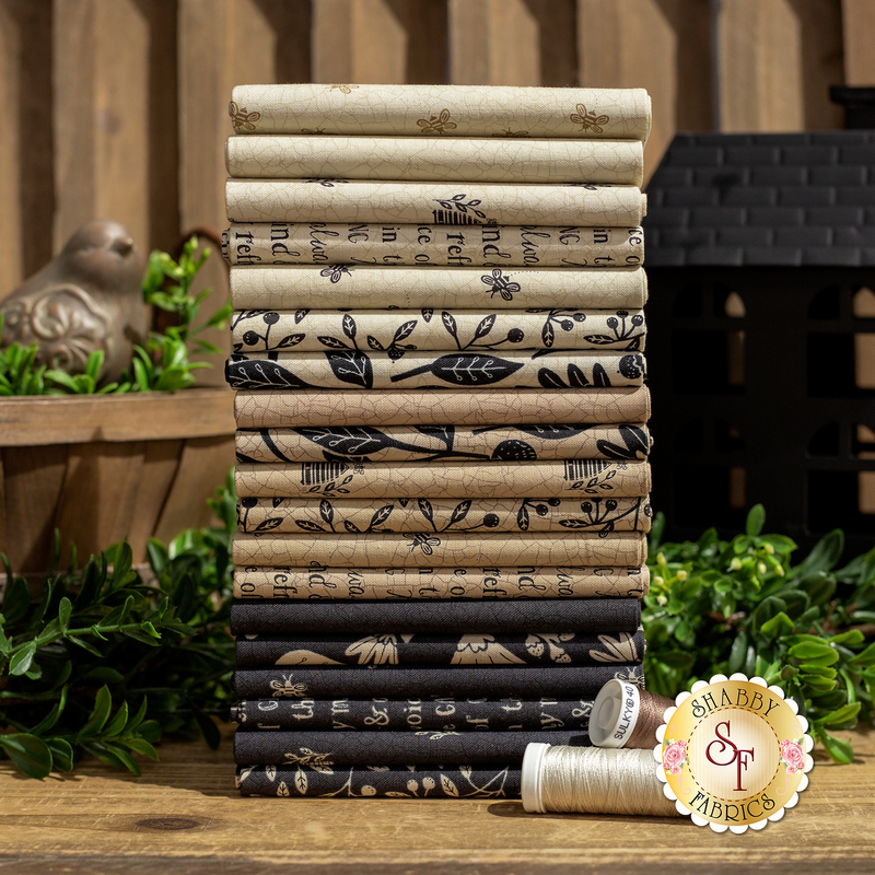 A photo of cream, tan, and black fat quarters stacked