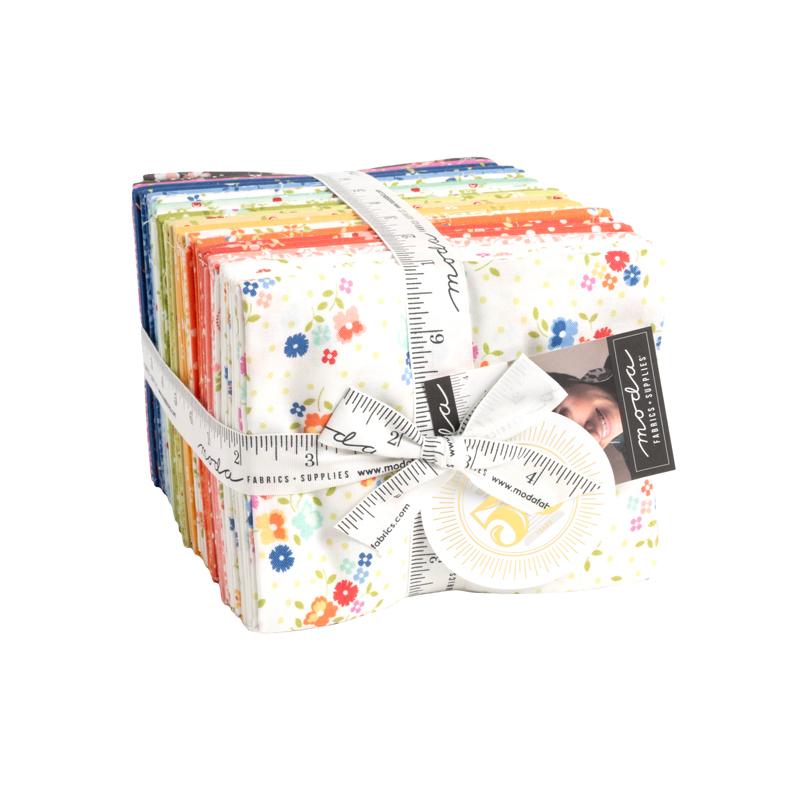 A bundle of white and multi colored fabrics with a ruler bowtie holding it together against a white background