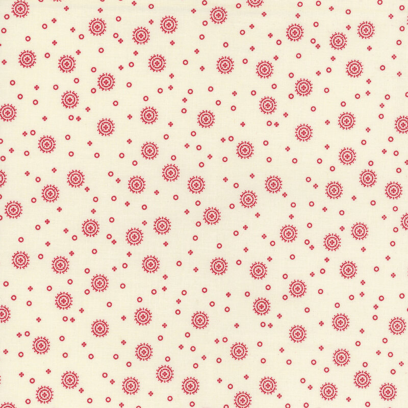 white fabric with tiny red circles and four-petaled flowers with larger circular sunbursts scattered across the fabric