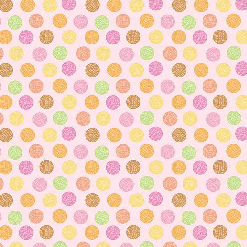 pink sewing fabric with colorful balls of yarn polka dots all over