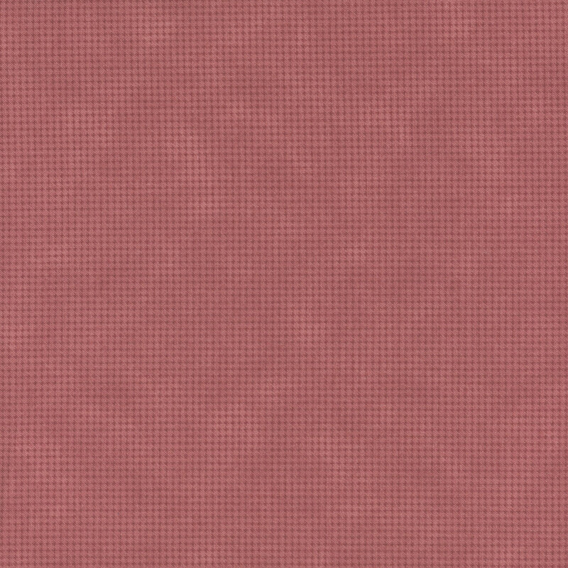 Mottled dusty red fabric with a small, repeating, dotted texture throughout