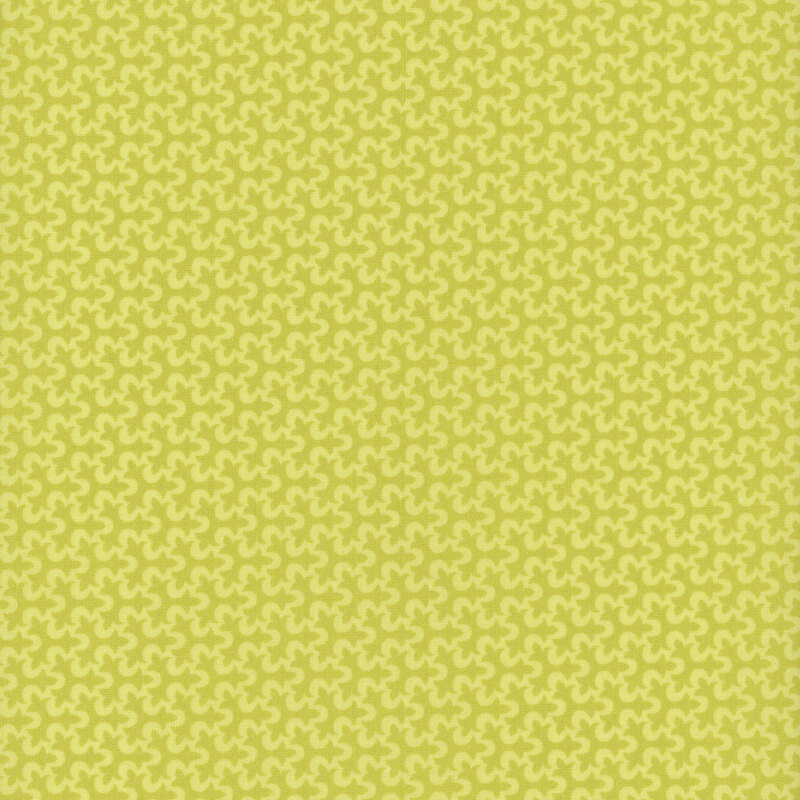 Fabric with a geometric fleur de lis pattern in tonal lime green.