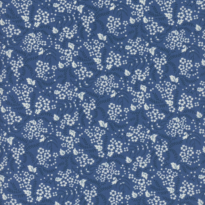 Dark navy blue fabric with clusters of white flowers and dark, navy blue leaves and vines