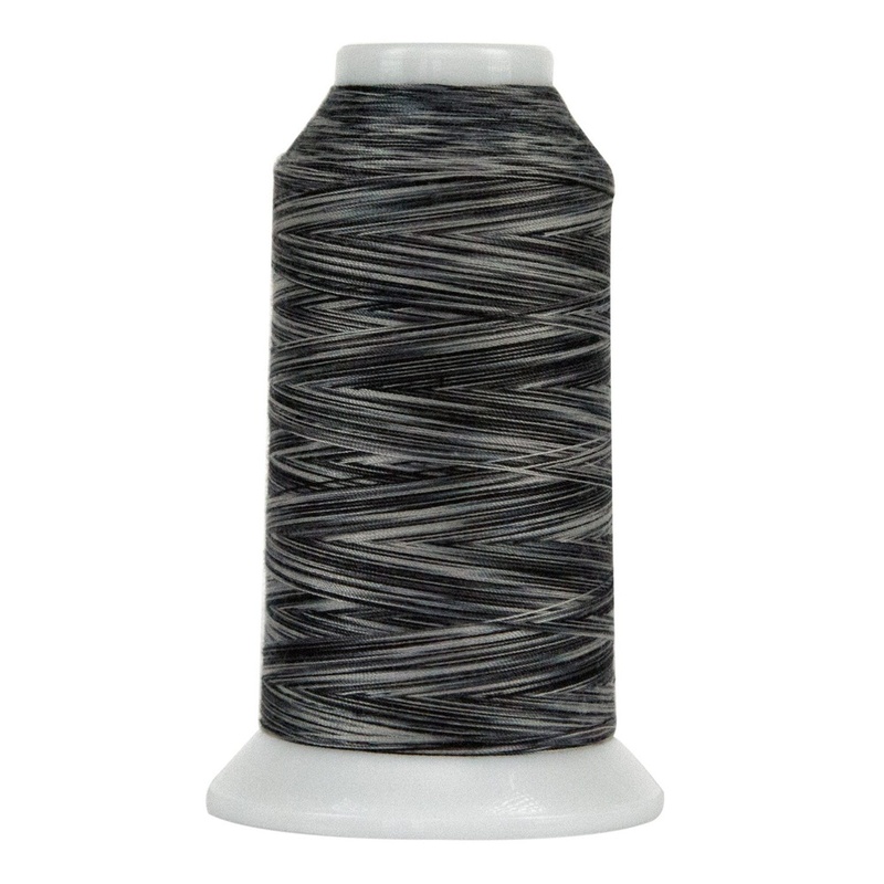 Spool of black and gray variegated thread, isolated on a white background.
