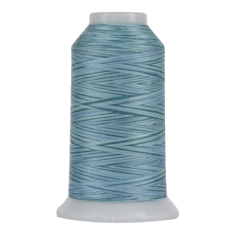 Variegated sky blue and teal spool of thread, isolated on a white background.