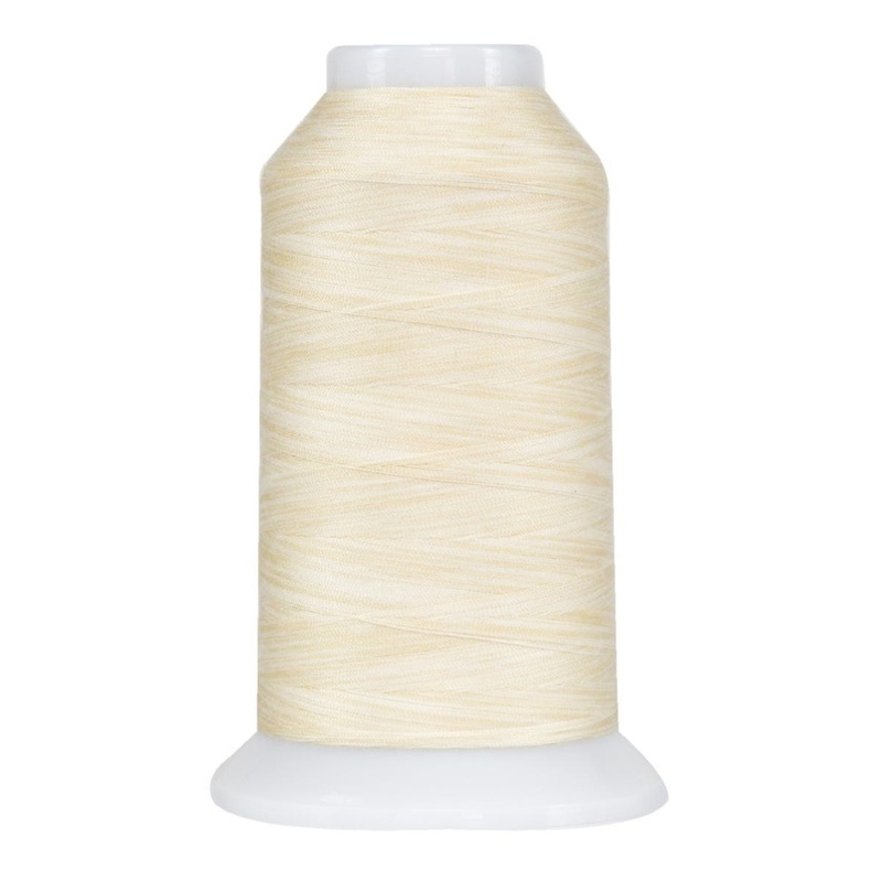 Very light white and cream spool of variegated thread, isolated on a white background.