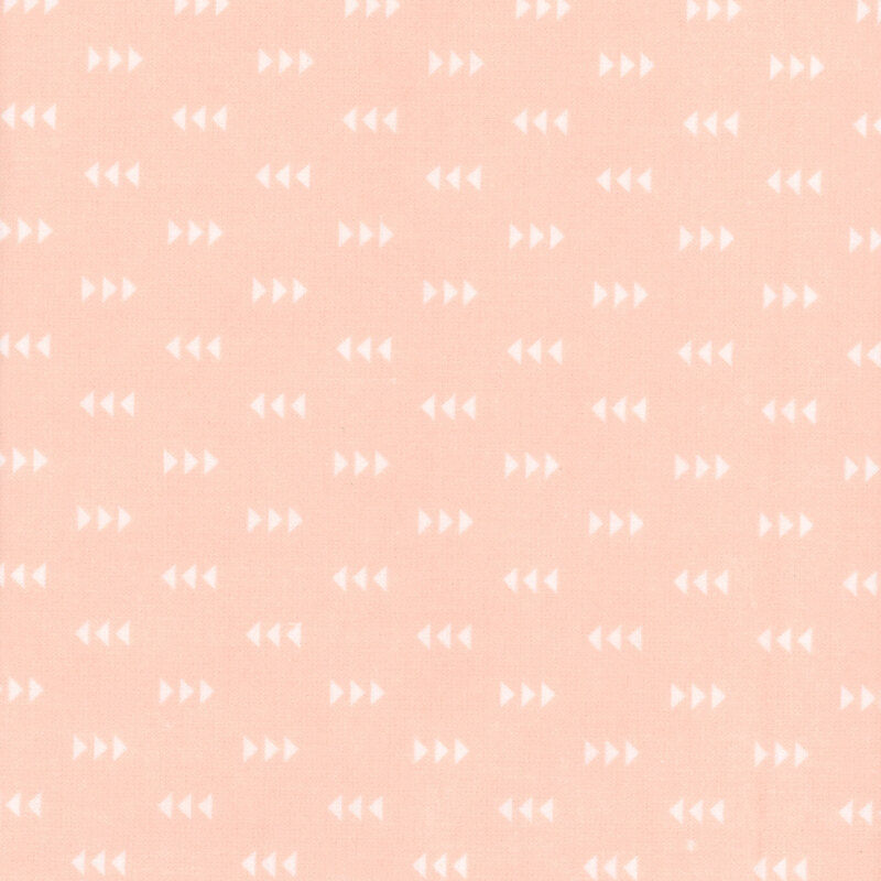Pastel peach fabric featuring a pattern of white triangles
