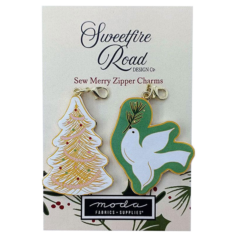 two enamel charms of a christmas tree and dove with a branch of mistletoe displayed on a Sweetfire Road Moda card