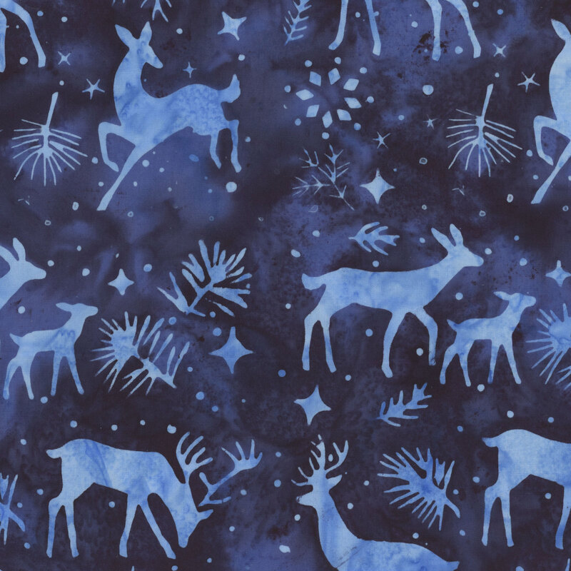 Dark blue batik with silhouettes of lighter blue deer, stars, pine sprigs, and snowflakes