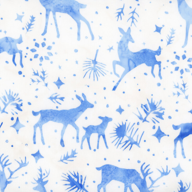 White batik fabric with blue mottled silhouettes of deer, snowflakes, pine sprigs, and stars