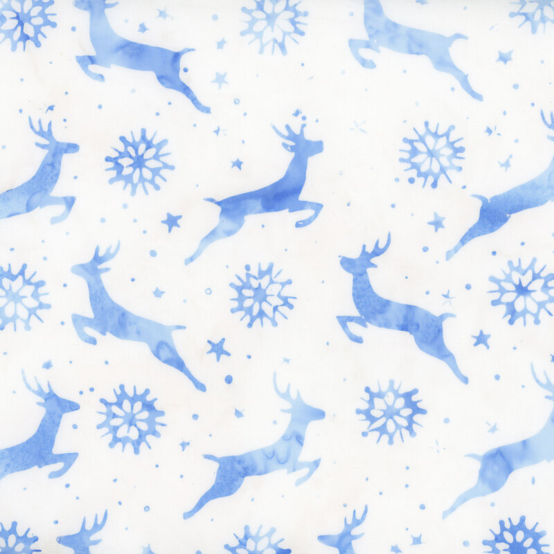 White batik fabric with light blue mottled silhouettes of dashing deer, snowflakes and stars
