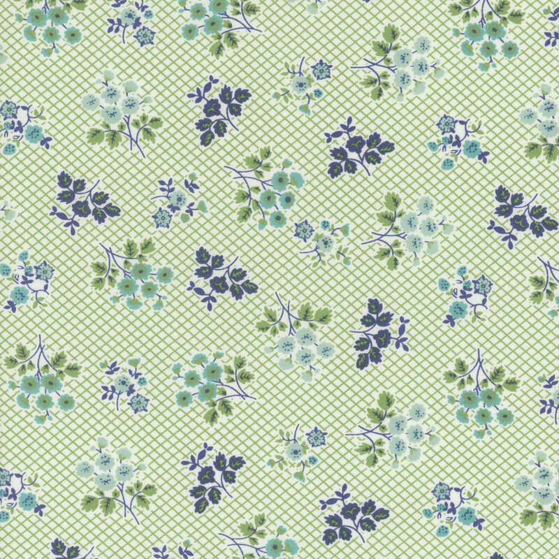 Fabric featuring clusters of blue and aqua flowers on a green lattice background