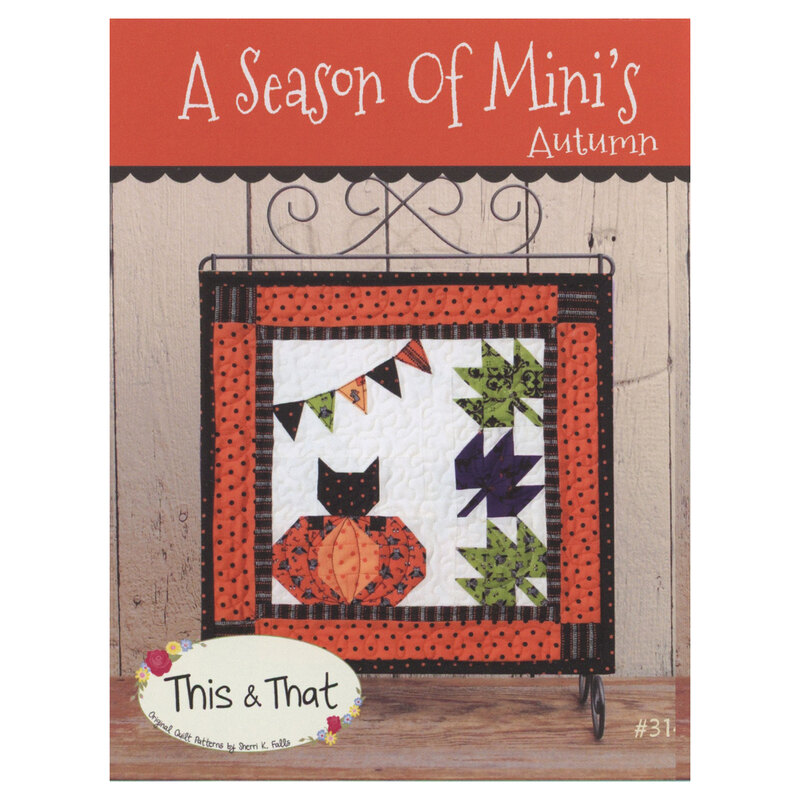 Front of A Season Of Mini's Autumn pattern featuring finished mini quilt displayed on a mini quilt hanger on a wooden table.