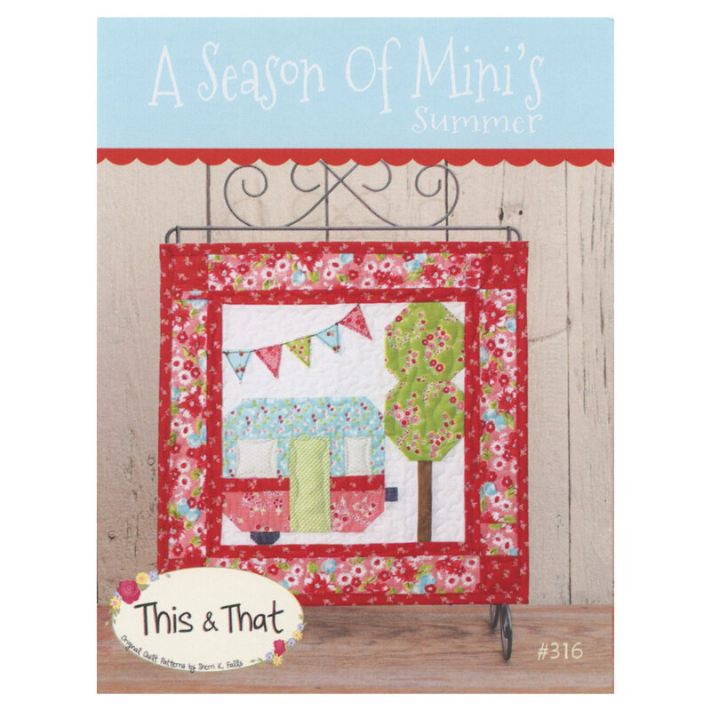Front of A Season Of Mini's Summer pattern featuring finished mini quilt displayed on a mini quilt hanger on a wooden table.